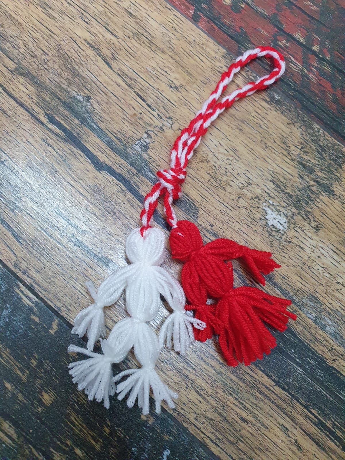Fată și băiat, moșternire culturală, lucrați din fir acrilic în culorile roșu și alb Fată și băiat, moșternire culturală, lucrați din fir acrilic în culorile roșu și alb